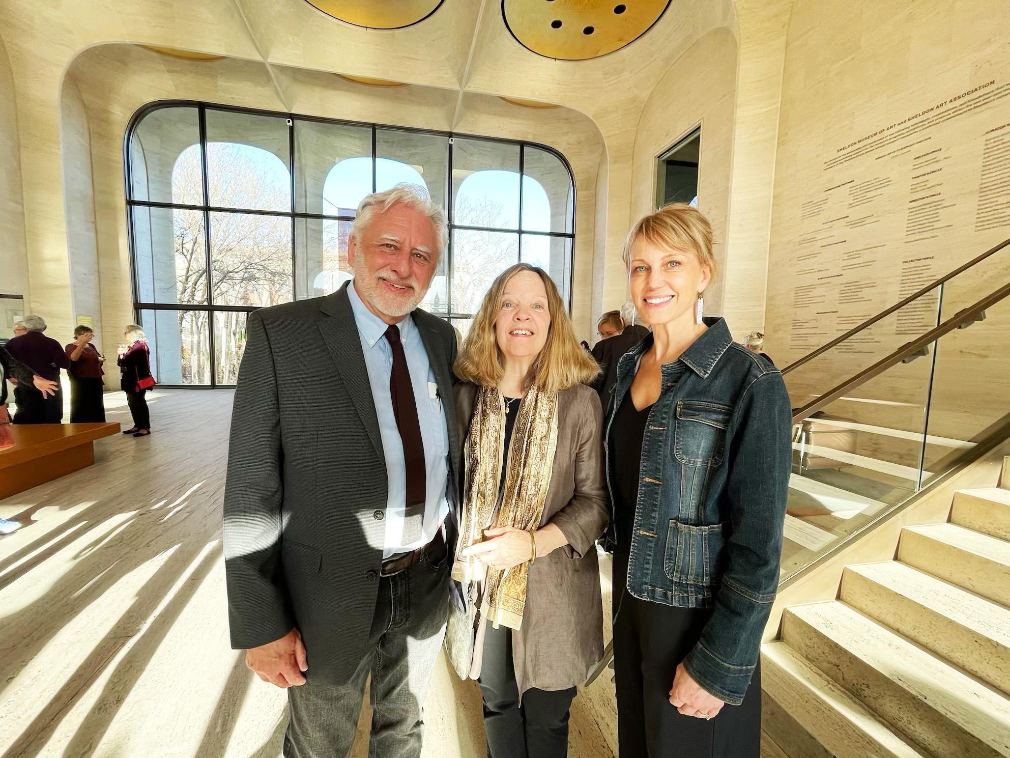 One man and two women smiling for a photo in business casual clothes