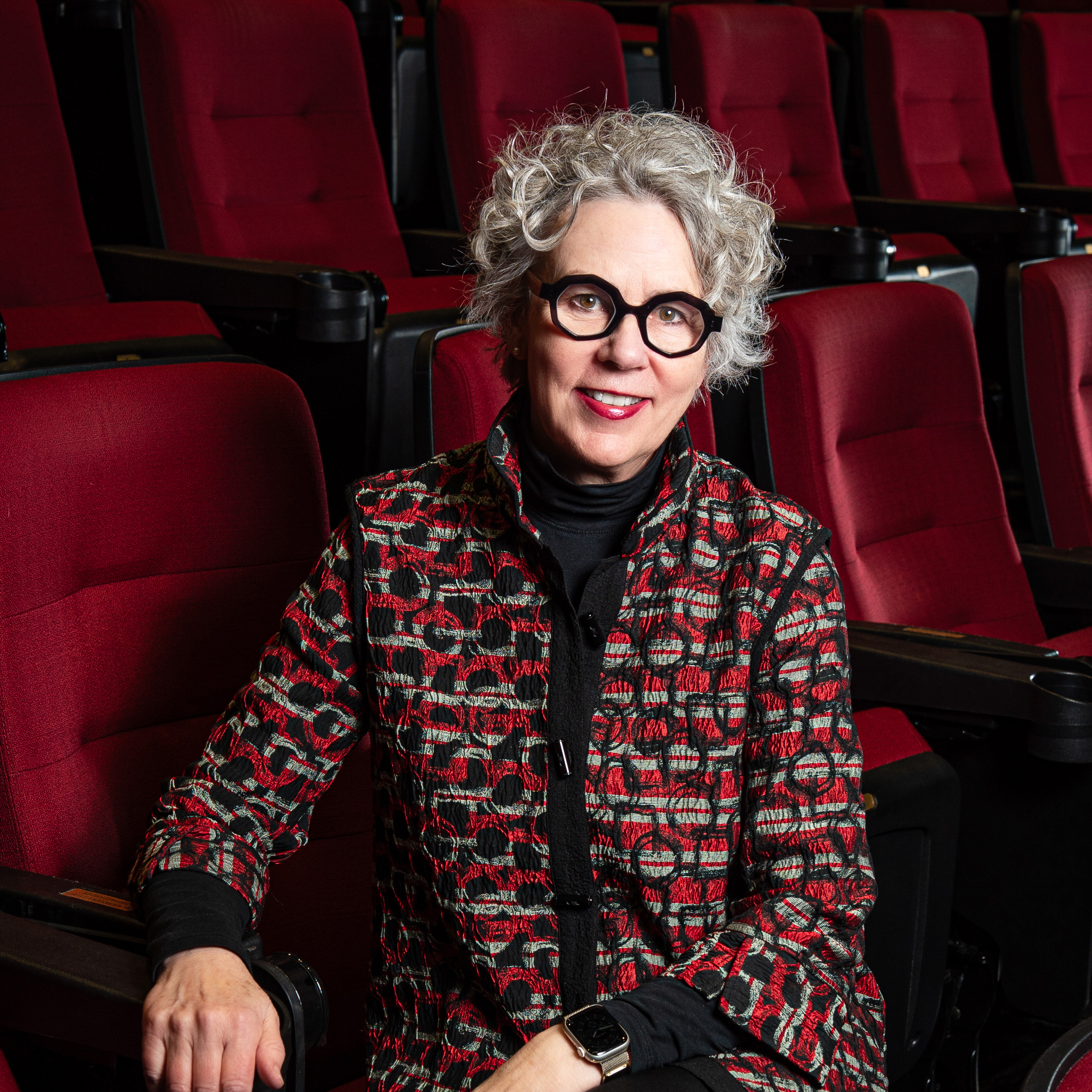 Photo of Laurie Richards sitting in a red theater chair
