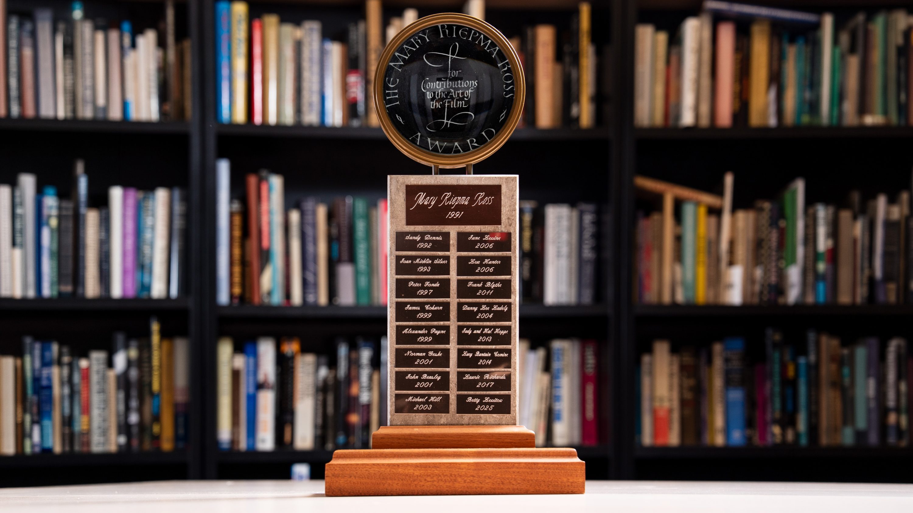 Mary Riepma Ross Award set on a table in front of a bookshelf