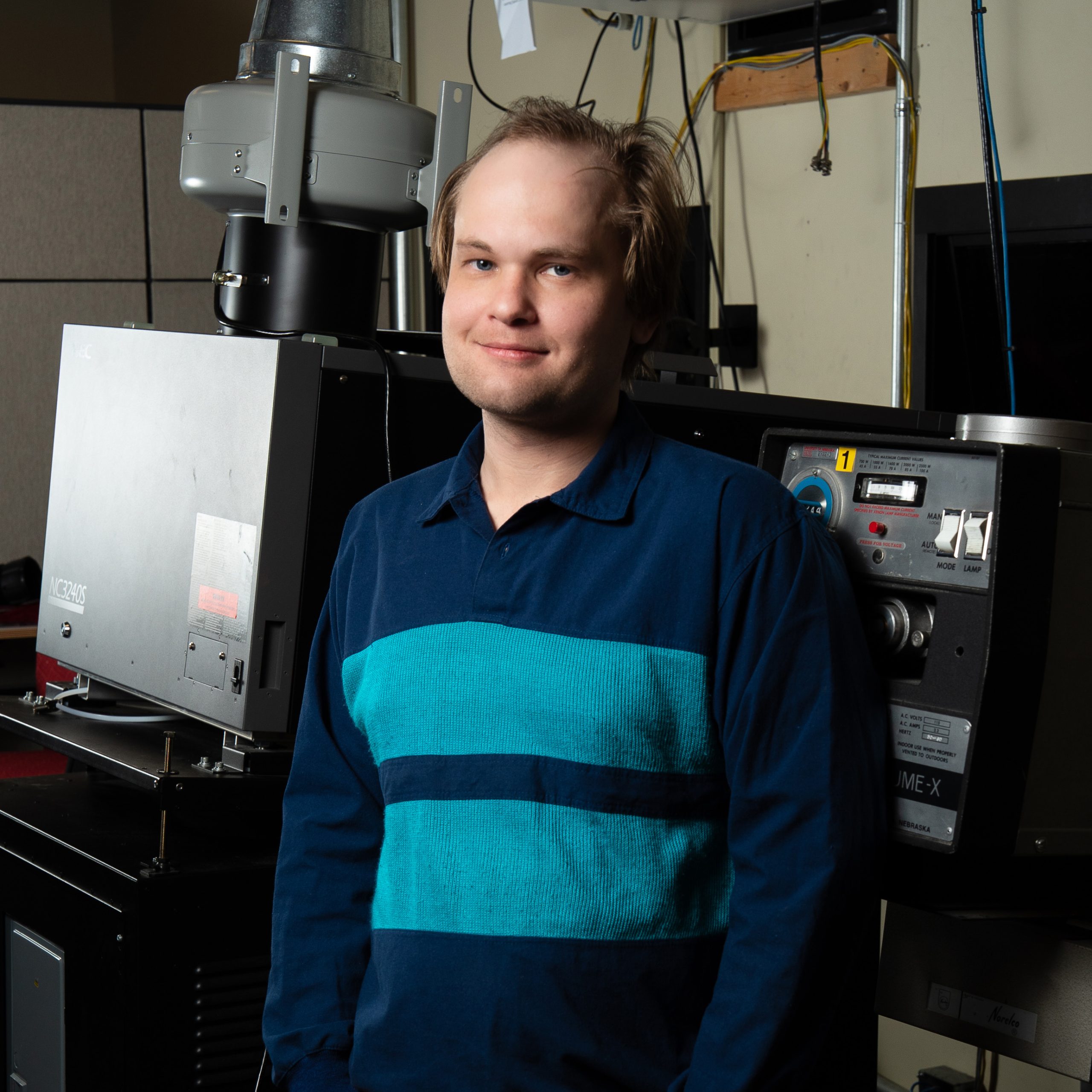 Photo of Phillip Malzer standing infront of tech equipment