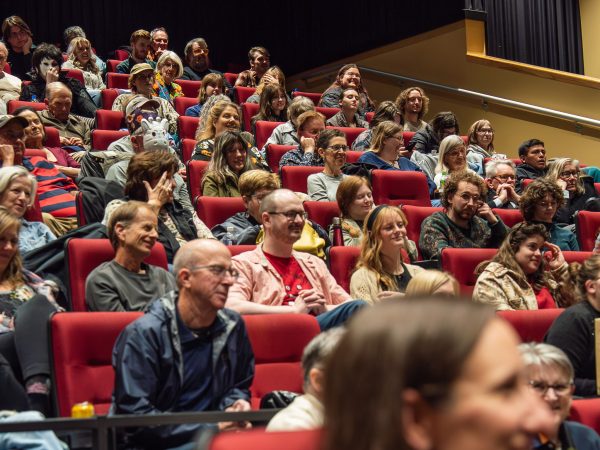 Theater seats full of people smiling