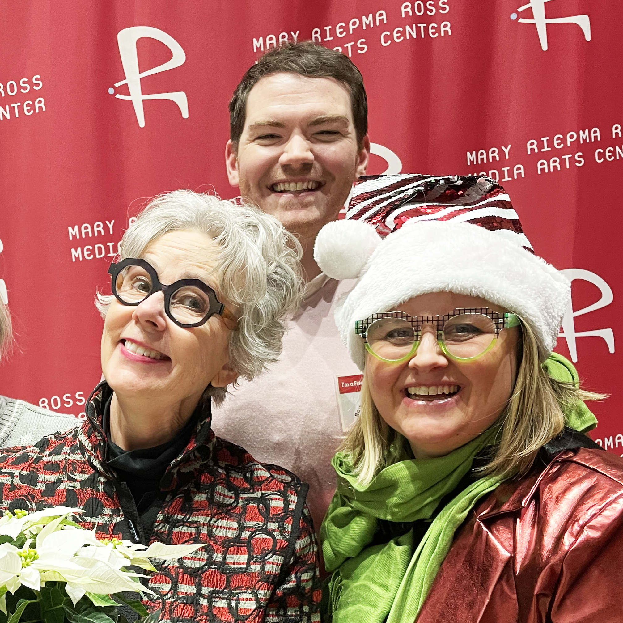 Photo of two women and a man dressed festively for a winter party