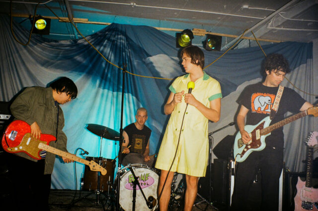 A scene from Mile End Kicks. An indie band is shown on stage mid-set.