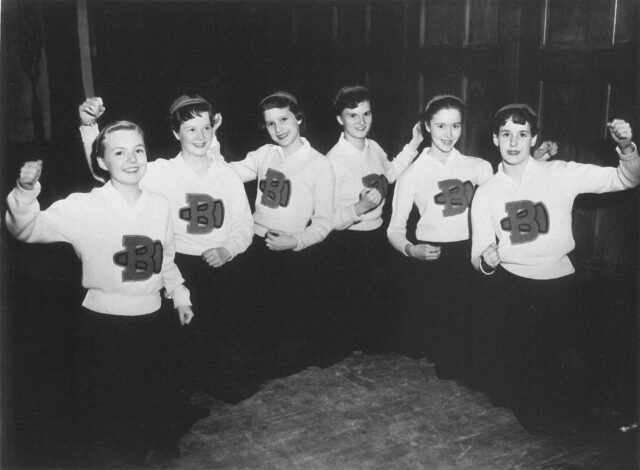 Group of cheerleaders from the 1960s, striking a pose.