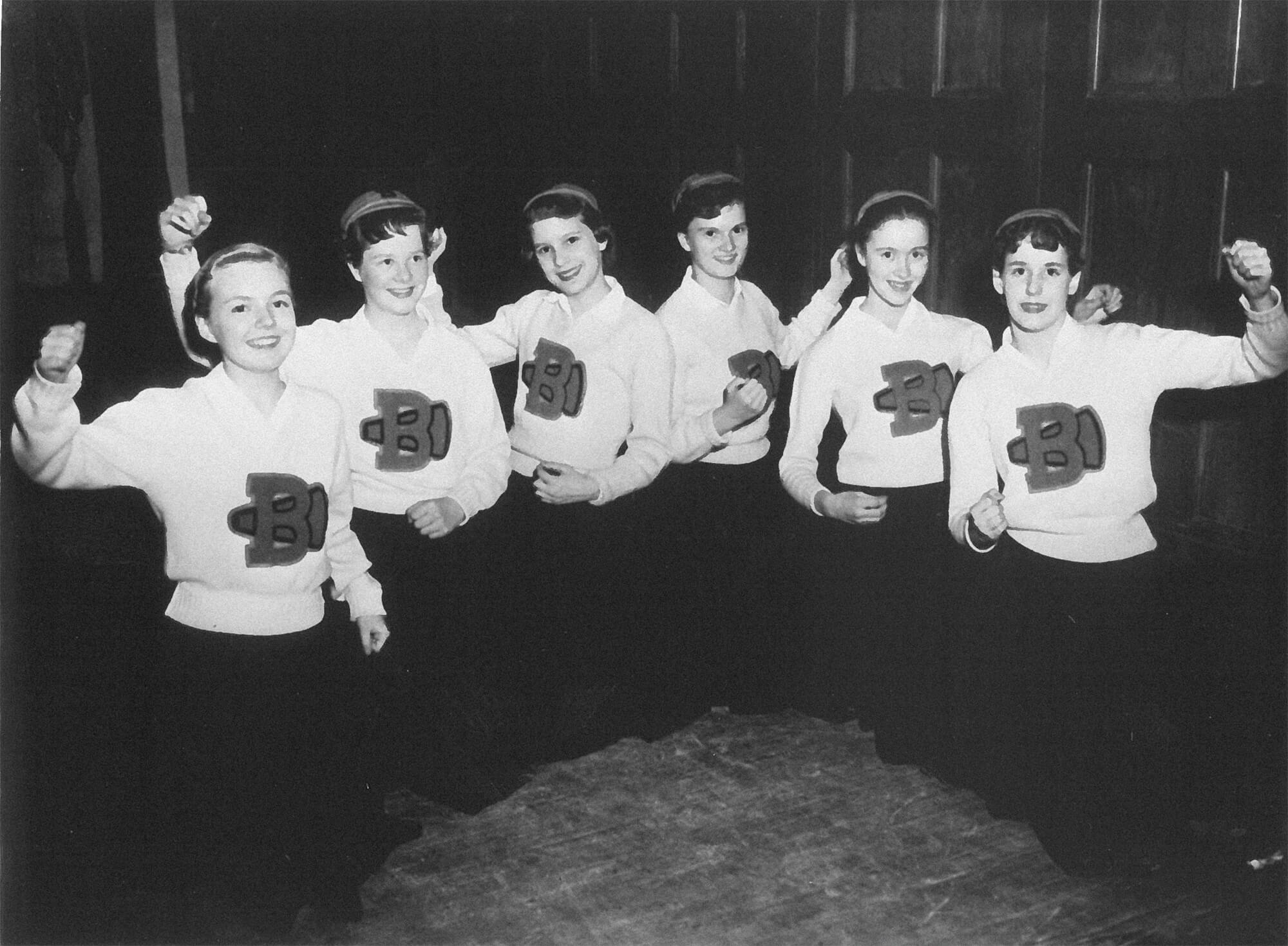 Group of cheerleaders from the 1960s, striking a pose.
