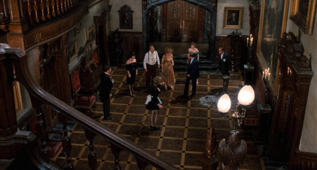 A group gathers in a mansion foyer in a scene from Clue.