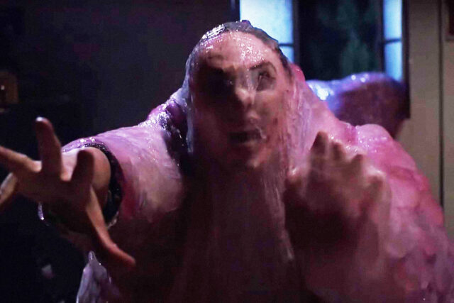 A person covered in pink goo in a scene from The Blob.