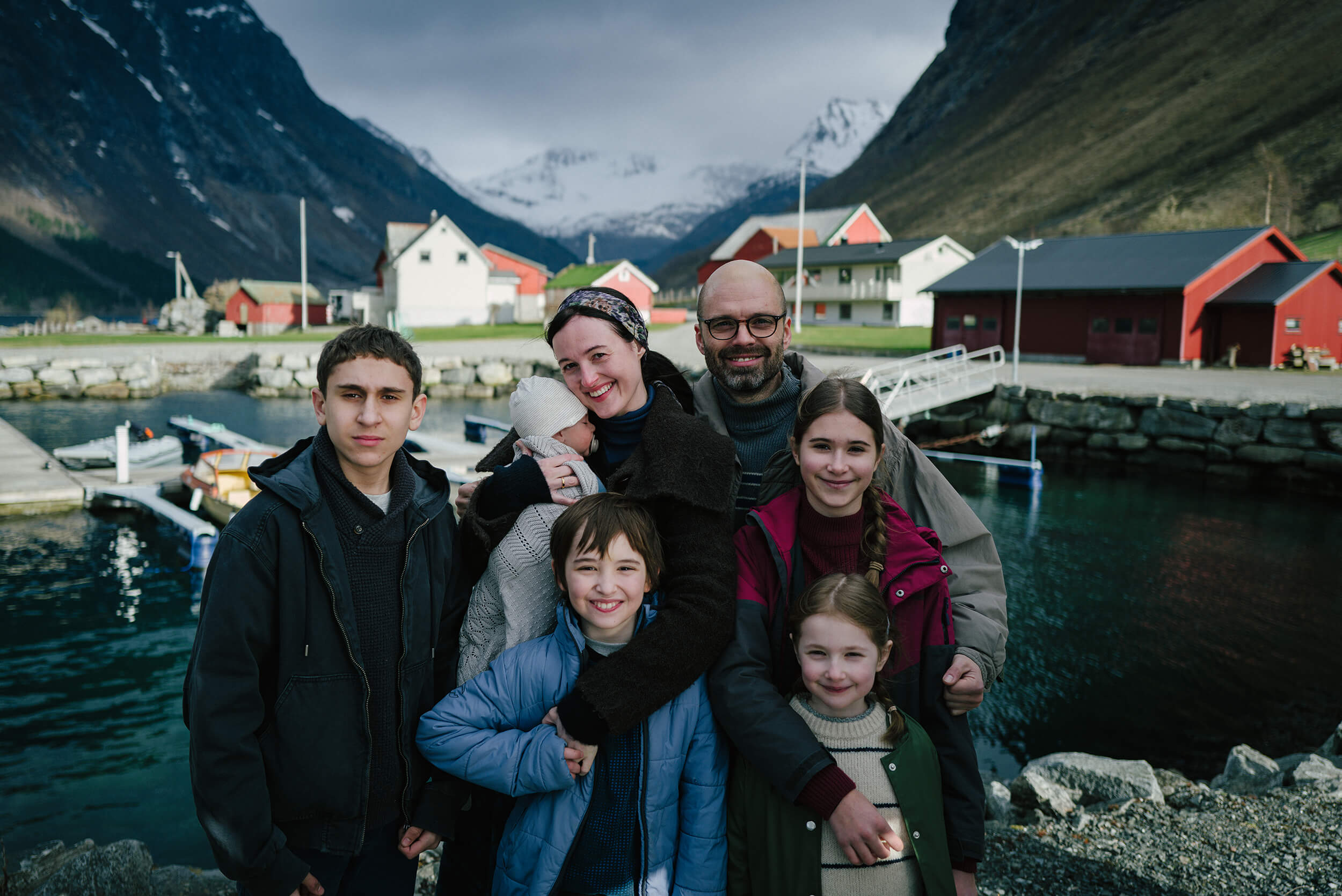 A family gathers for a family portrait at a harbor in a scene from Fjord.