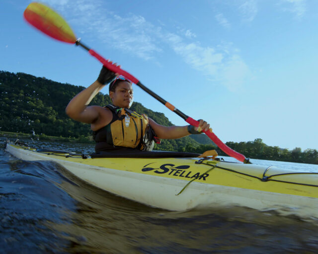A person rows a kayak in a scene from the short film Mother River.